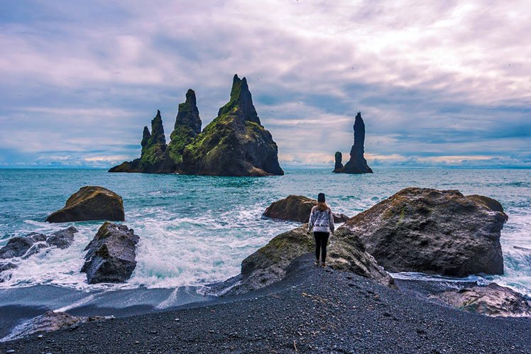 Looking out towards the Reynisdrangar basalt sea stacks from Reynisfjara Beach © Sasha64f / Shutterstock