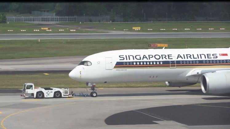A Singapore Airlines passenger plane is towed to the terminal area of Changi International Airport on December 7, 2020. 
