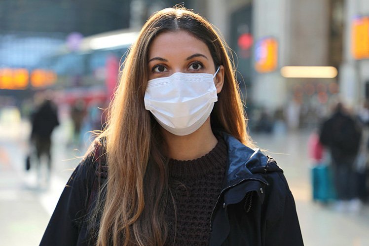 Travelers wearing protective masks walk through LaGuardia Airport (LGA) in New York, US on Christmas Eve © Bloomberg via Getty Images