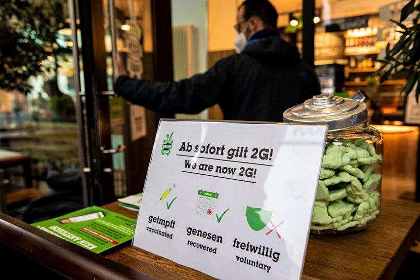 A sign "We are now 2G" at the door to a restaurant indicates entry only for vaccinated and recovered people © Maja Hitij/Getty Images